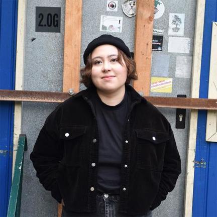 person standing in front of barred door, smiling