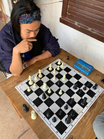 person thinking in front of a chess board