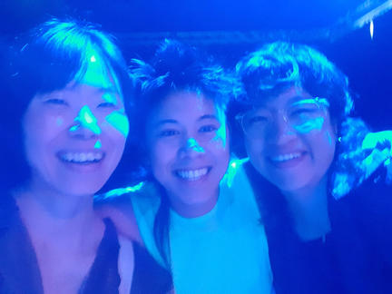 3 persons smiling into the camera in ble light